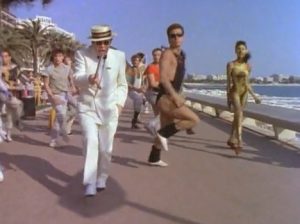 Elton John Still Standing dancing on the beach
